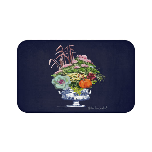 A rectangular mat with rounded corners featuring a dark navy blue background and a central illustration of a floral arrangement in a blue-and-white pedestal bowl, with the text 'Giraffe and Garden' printed near the bottom right.