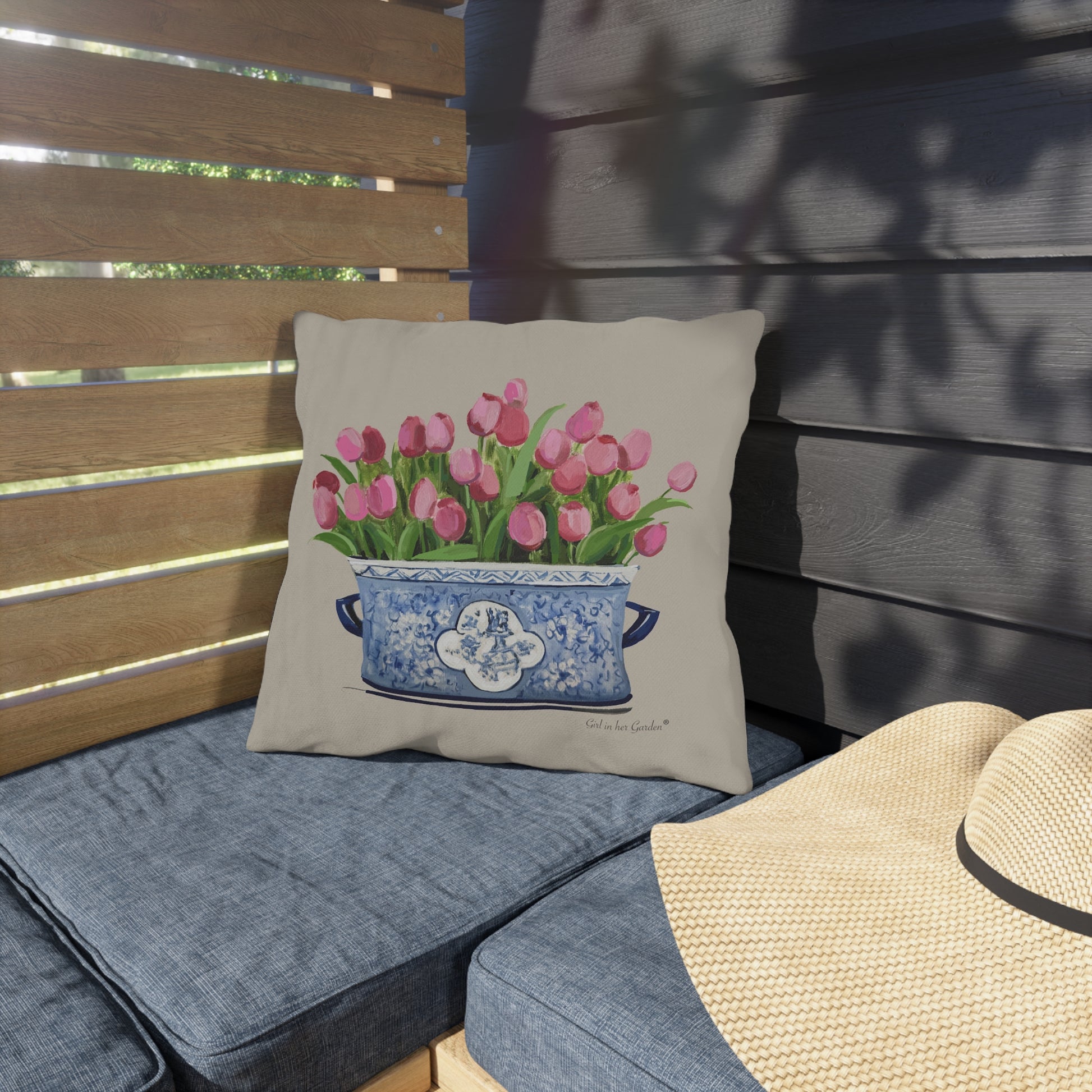 Decorative pillow with tulip design on a cushioned outdoor bench.