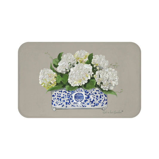 Decorative mat with white flowers in a blue and white container on a beige background