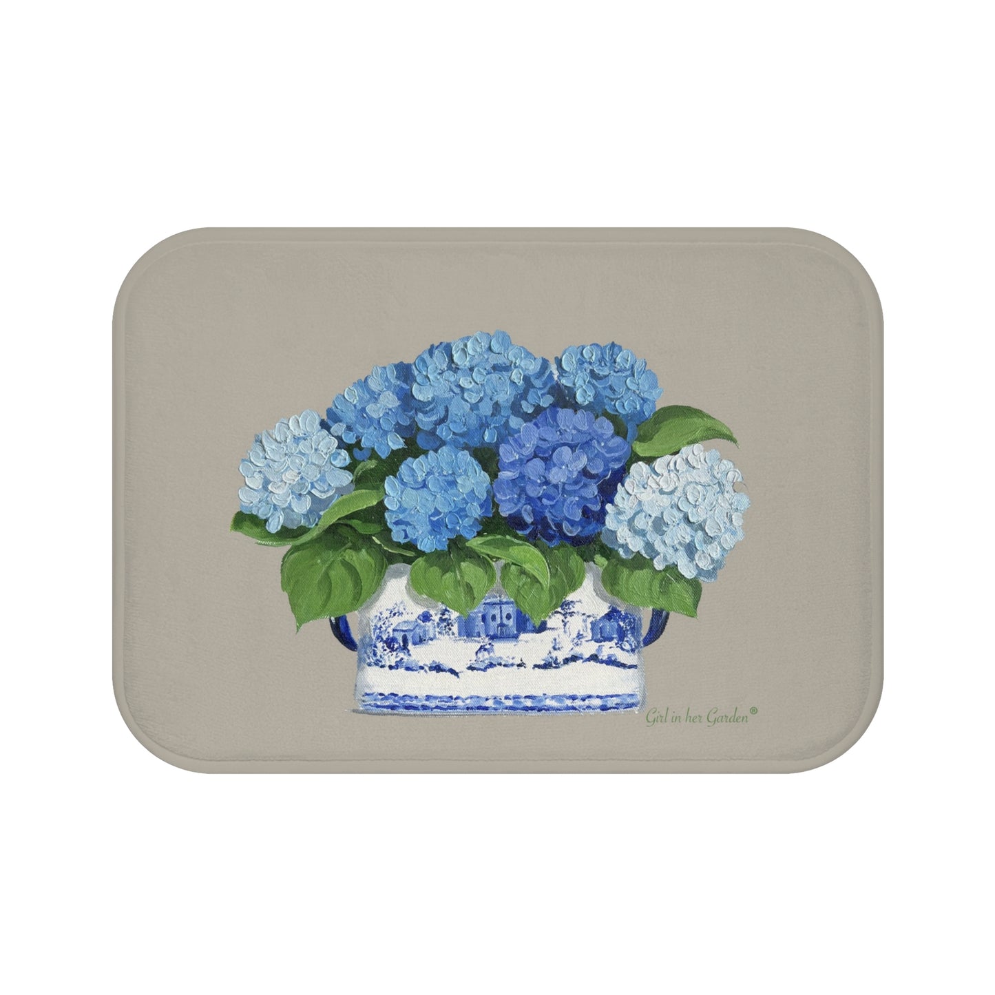 A beige kitchen, bath cushion mat with blue hydrangeas in a chinoiserie foot planter printed on it.