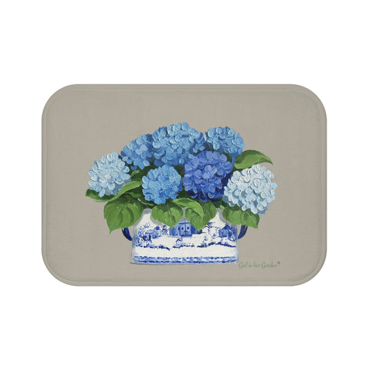 A beige kitchen, bath cushion mat with blue hydrangeas in a chinoiserie foot planter printed on it.
