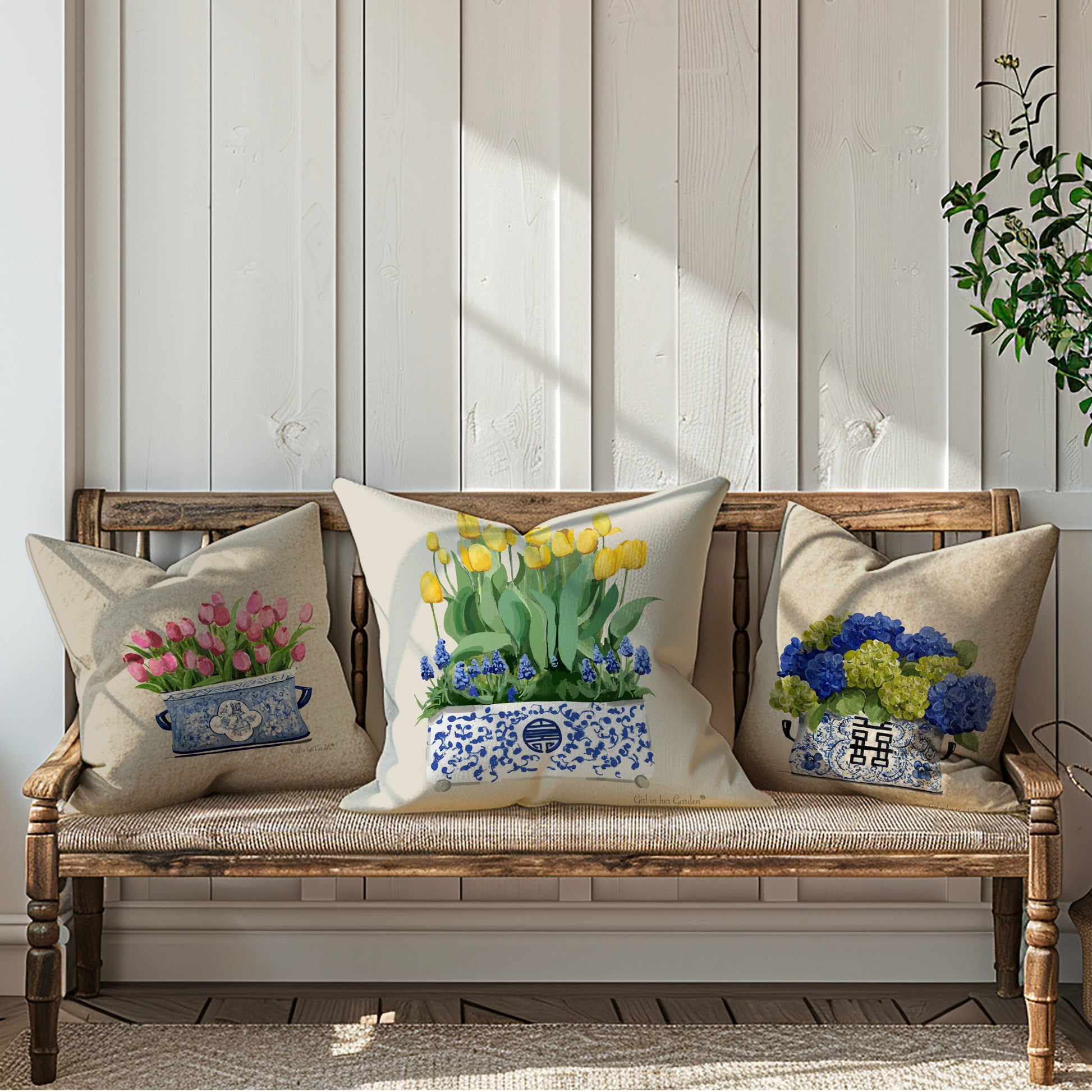 Decorative pillows with floral designs on a wooden bench against a light wooden paneled wall.