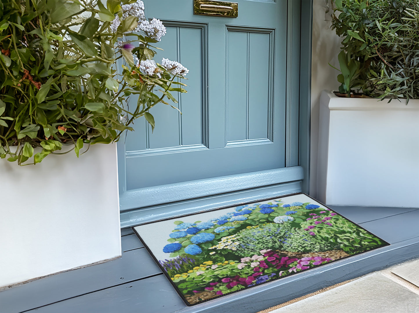 Decorative doormat with garden design in front of a blue door