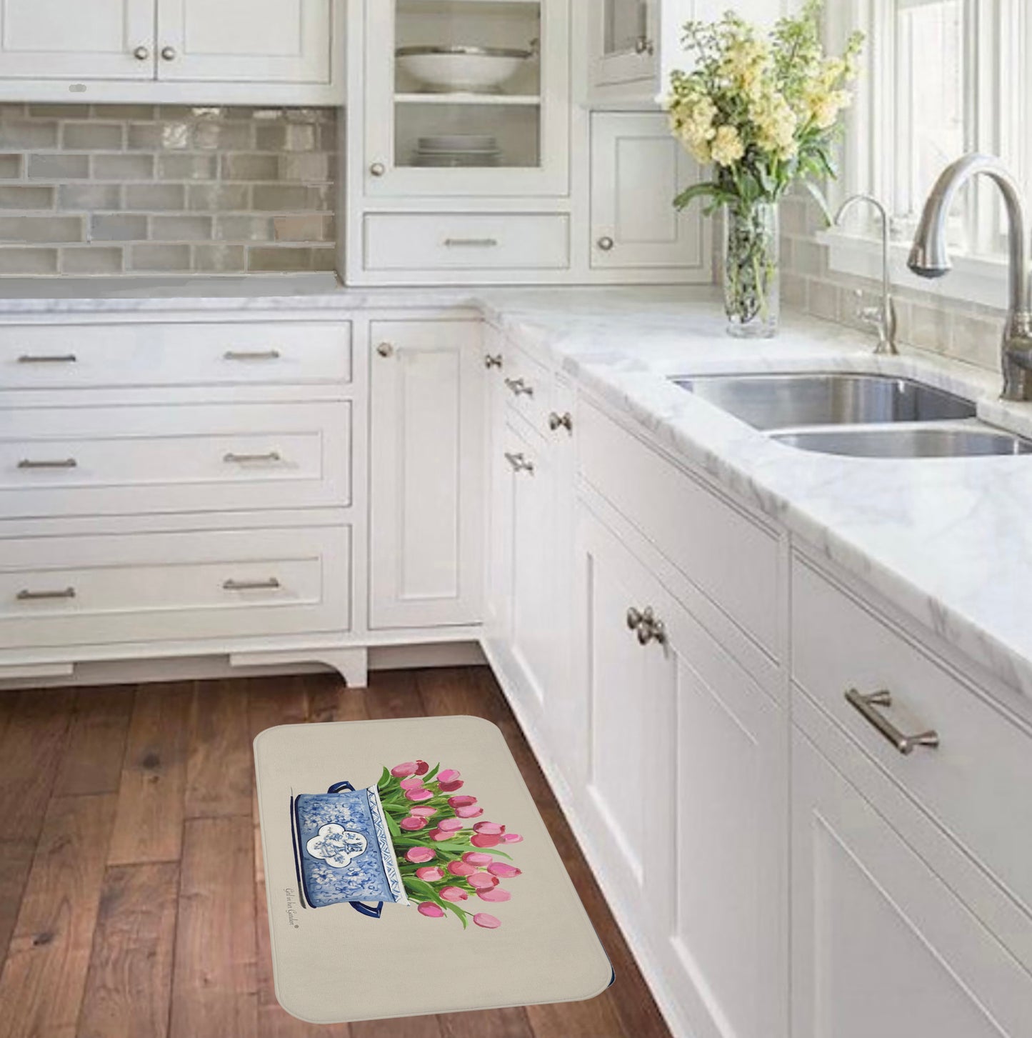Kitchen with a decorative rug featuring a blue teapot and pink tulips on a wooden floor.