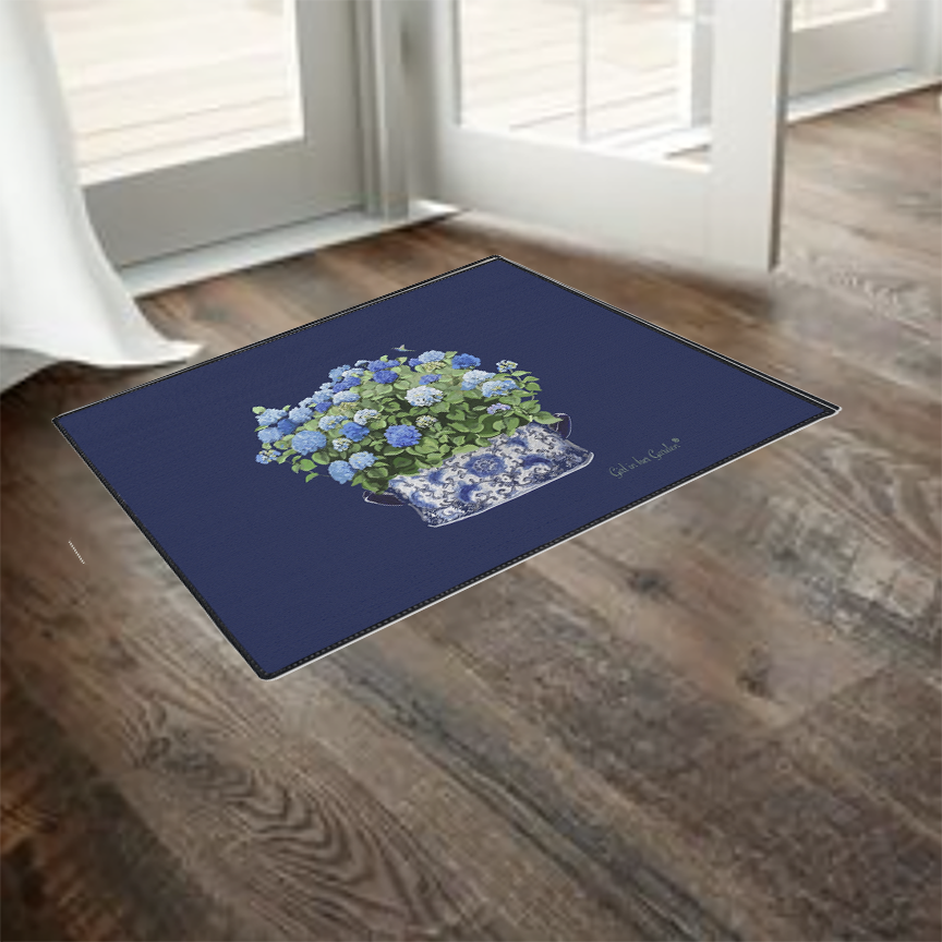 Navy blue doormat with floral design on a wooden floor