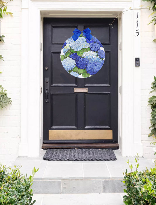 Decorative wreath with blue and green flowers on a black door.