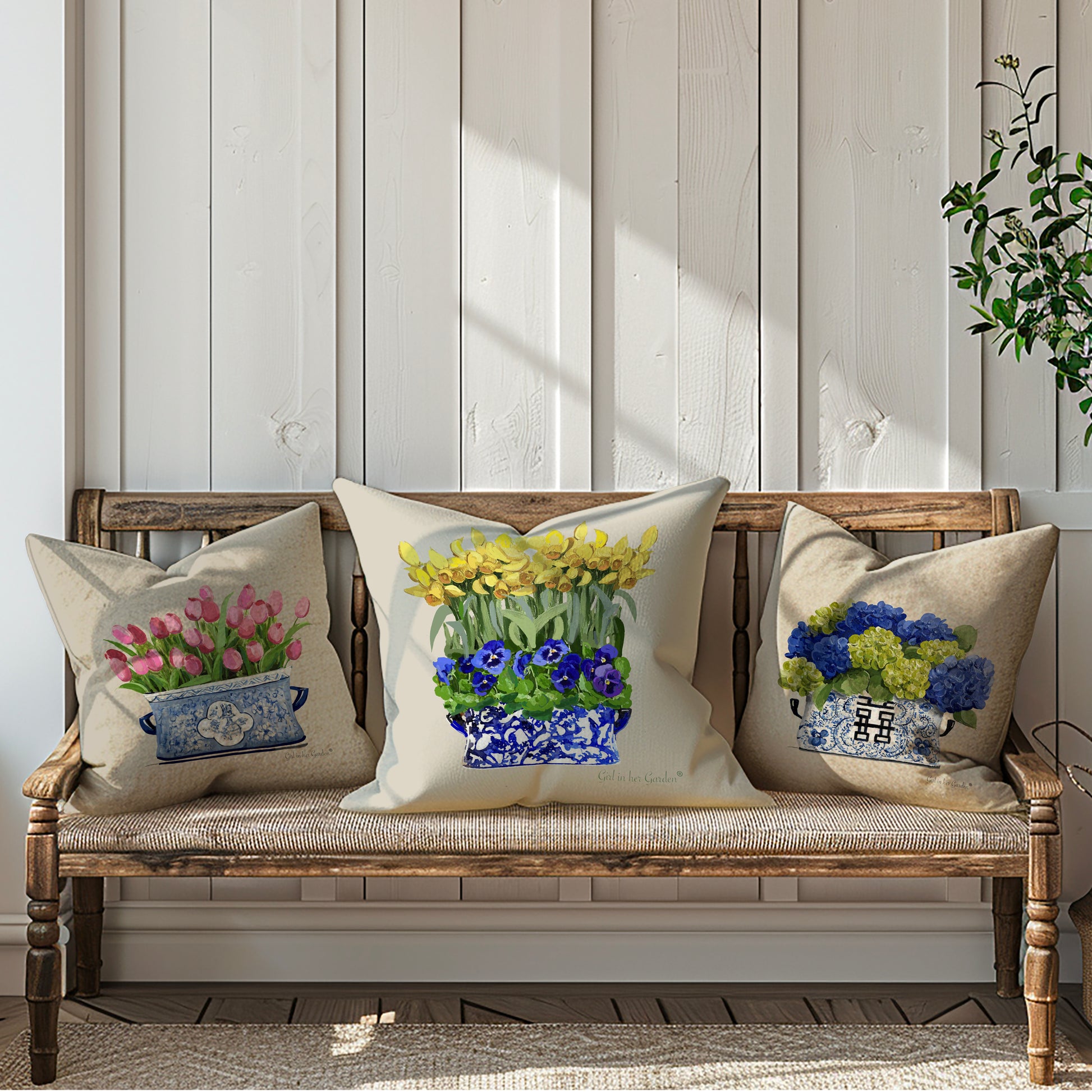 Decorative pillows with floral designs on a wooden bench against a light wooden paneled wall.