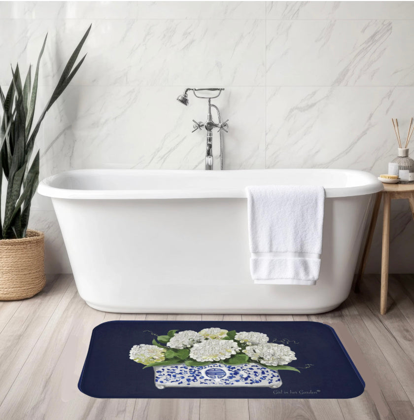 Bath mat with floral design in front of a white bathtub in a bathroom setting