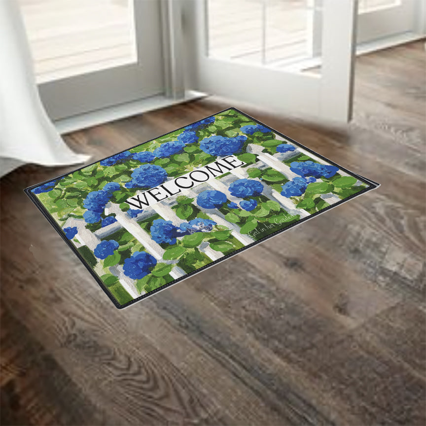 Decorative doormat with floral design and 'WELCOME' text on a wooden floor.