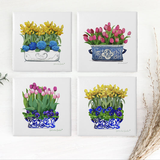 Four square tiles with floral designs on a white background